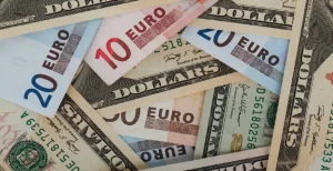 A mixture of Euro banknotes and US Dollar bills scattered together