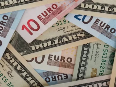 A mixture of Euro banknotes and US Dollar bills scattered together