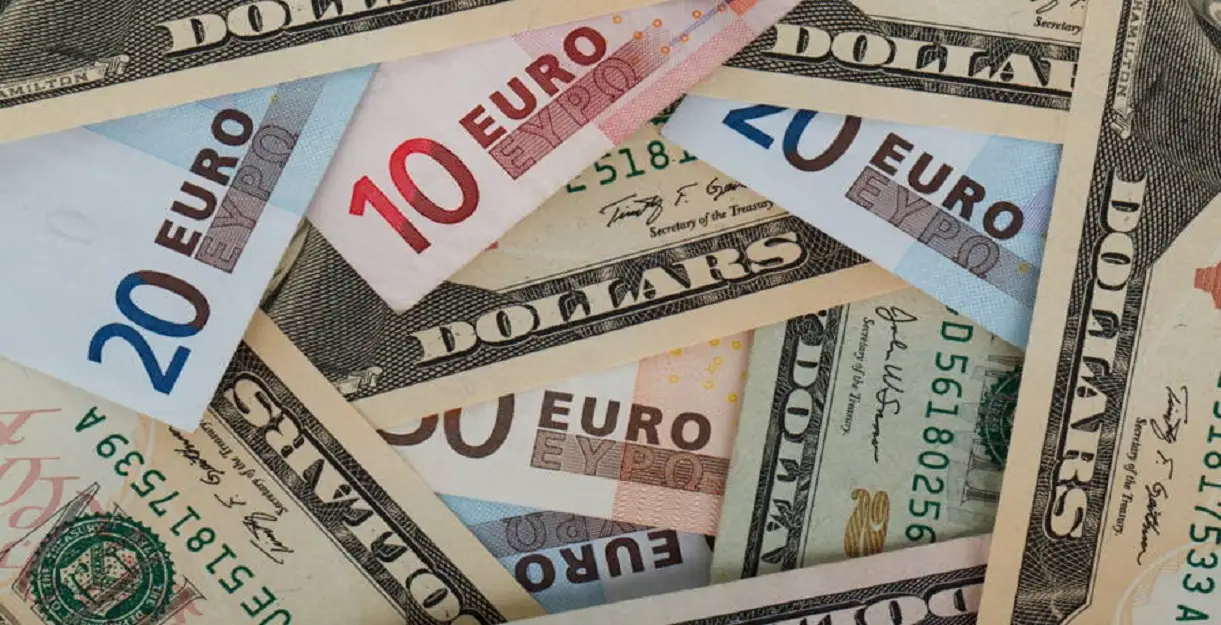 A mixture of Euro banknotes and US Dollar bills scattered together