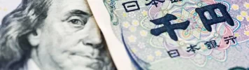 A close-up of a US dollar bill and a Japanese yen note placed side by side- usdjpy