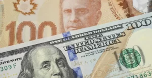 USD CAD - The image shows US and Canadian dollar banknotes placed side by side