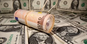 EURUSD - Rolled euro bills resting on a background of US dollars