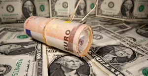 EURUSD - Rolled euro bills resting on a background of US dollars