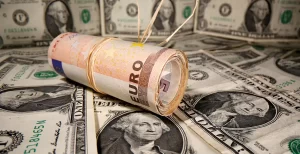 EURUSD - Rolled euro bills resting on a background of US dollars