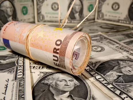 EURUSD - Rolled euro bills resting on a background of US dollars -2025